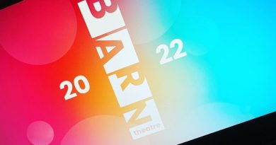 Barn Theatre Cirencester Launch. The theatre logo is in the centre of the screen with a mix of light blue splash of colour to the right and reds, pinks and oranges to the left