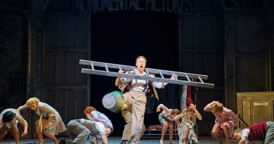 Singing in the Rain Bristol Hippodrome. Kevin Clifton features prominently in the image having a slap stick moment of ladder stuck over his head with bucket on foot. Dancers in the background are ducking to the floor