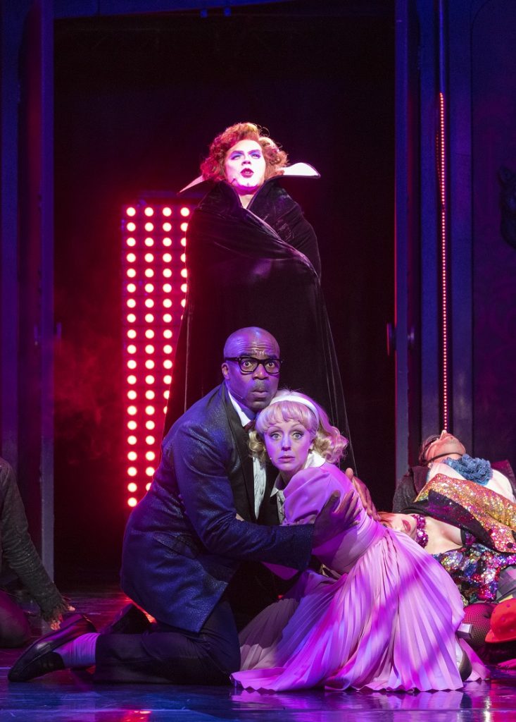 Ore Oduba Bristol Hippodrome - Photo features Ore Oduba as Brad, in a production shot with Janet huddled next to him and Frank towering above