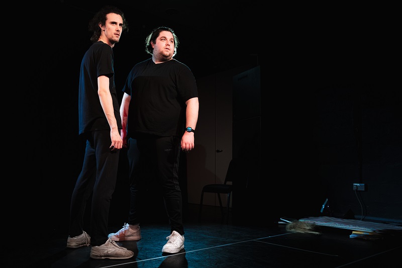 Jack and Jordan A Sketch Show Two men dressed in black stand on a stage looking into the distance