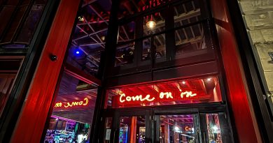 Main entrance to Bristol Old Vic Theatre. It's lots of angular squares with red lighting.