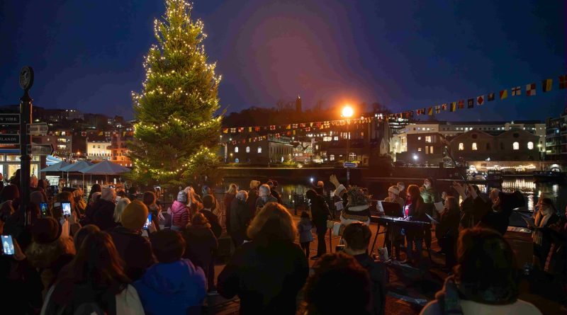 SS Great Britain Tree and Golden Ticket Programme - A photograph of people gathered around a large, brightly lit Christmas tree at night