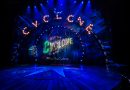Ride The Cyclone Southwark Playhouse London - A photograph that's very blue with Cyclone in lights and in text on a curtain below. There is a blue semi circle low stage with a star on