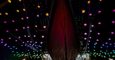 SS Great Britain Beneath The Waves Bristol Christmas Lights - The hull of the ship in the dry dock surrounded by balls of rainbow lights